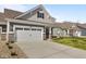 Inviting home featuring a large driveway leading to a two-car garage, complemented by a well-maintained lawn at 16771 Cattle Hollow Ln, Noblesville, IN 46060