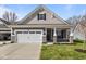 Charming home featuring a two-car garage, a well-manicured lawn, and stylish stone accents on the facade at 16771 Cattle Hollow Ln, Noblesville, IN 46060