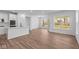 Bright living area with wood-look floors, large windows, and an open kitchen featuring a center island at 16771 Cattle Hollow Ln, Noblesville, IN 46060