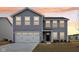 Charming two-story home with gray siding, a two-car garage, and manicured front yard at sunset at 1854 Cascades Dr, Greenfield, IN 46140