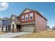 Two-story home with red siding, a covered porch, an attached garage, and a well-maintained lawn at 1945 Clement St, Westfield, IN 46074