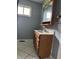 Bathroom featuring a wood vanity, marble countertop, wood medicine cabinet, and white tiled floors at 2346 Mayfair Dr, Indianapolis, IN 46260