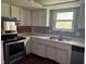 Functional kitchen featuring white cabinets, laminate countertops, and stainless steel appliances at 2346 Mayfair Dr, Indianapolis, IN 46260