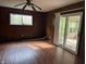 Living room featuring wood-paneled walls, laminate floors, a ceiling fan, and access to a sunroom at 2346 Mayfair Dr, Indianapolis, IN 46260