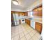 Well-lit kitchen features stainless steel refrigerator, white appliances, and tiled floor at 2523 S Mcclure St, Indianapolis, IN 46241