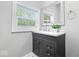 Bathroom with a gray vanity with countertop, a decorative mirror, and a window that provides natural light at 2528 Guilford Ave, Indianapolis, IN 46205