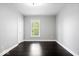 This bedroom features dark wood floors, fresh paint, a window for natural light, and standard lighting at 2528 Guilford Ave, Indianapolis, IN 46205