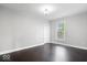 This bedroom features dark wood floors, fresh paint, a window for natural light, and standard lighting at 2528 Guilford Ave, Indianapolis, IN 46205
