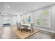 Open dining area with a large table and comfortable seating, with views through large windows at 2528 Guilford Ave, Indianapolis, IN 46205
