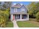 Charming blue two-story home featuring a cozy front porch with swing and manicured lawn at 2528 Guilford Ave, Indianapolis, IN 46205