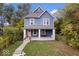 Charming blue two-story home featuring a cozy front porch with swing and manicured lawn at 2528 Guilford Ave, Indianapolis, IN 46205