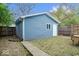 View of a detached garage with blue siding and a small yard with mature trees at 2528 Guilford Ave, Indianapolis, IN 46205