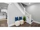 Stylish hallway features a staircase, two poufs with pillows, and a glimpse of the kitchen at 2528 Guilford Ave, Indianapolis, IN 46205