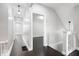 Hallway with wood floors, white trim, and pendant lighting leading to additional rooms at 2528 Guilford Ave, Indianapolis, IN 46205