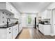 Bright kitchen with stainless steel appliances, white cabinets, modern backsplash, and hardwood floors at 2528 Guilford Ave, Indianapolis, IN 46205