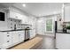 Beautiful kitchen featuring white cabinetry, stainless steel appliances and stylish backsplash and a large window for natural light at 2528 Guilford Ave, Indianapolis, IN 46205