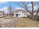 View of a house with a fenced yard, surrounded by trees and a blue sky backdrop at 2532 Madison Ave, Indianapolis, IN 46225