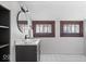 Bathroom featuring a vanity, mirror, white and black tile flooring, and natural light from the window at 2532 Madison Ave, Indianapolis, IN 46225