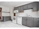 This well-lit kitchen has gray cabinets, white appliances, and tile floors providing a clean and modern look at 2532 Madison Ave, Indianapolis, IN 46225