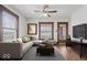 Bright living room with a gray sofa, ceiling fan, and hardwood floors offers a cozy and inviting space at 2532 Madison Ave, Indianapolis, IN 46225