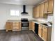 Bright kitchen with light wood cabinets, black appliances, and plenty of counter space for cooking at 2712 S A St, Elwood, IN 46036