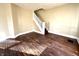 Inviting living room with original hardwood floors, staircase, and natural light streaming through the window at 2821 E 13Th St, Indianapolis, IN 46201