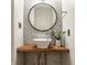 Stylish half bath with a vessel sink, wooden countertop, a round mirror, and an elegant hexagon tile wall at 304 E 17Th St, Indianapolis, IN 46202