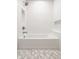 Clean, bright bathroom with a classic white bathtub and shower combination and geometric tiled floor at 304 E 17Th St, Indianapolis, IN 46202