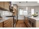 Open kitchen featuring modern appliances, wooden cabinets, tile backsplash, and hardwood floors at 304 E 17Th St, Indianapolis, IN 46202