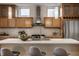 Close-up view of the modern kitchen island with stainless steel appliances, cabinets, and stylish gray bar stools at 304 E 17Th St, Indianapolis, IN 46202