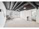 Finished basement offers additional living space with exposed ceiling and walkout doors to view at 3155 N White River Pkwy E Dr, Indianapolis, IN 46208