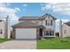 Charming two-story home with a well-manicured lawn and attached two-car garage at 3155 N White River Pkwy E Dr, Indianapolis, IN 46208