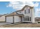 Two-story home featuring vinyl siding, an attached garage, and landscaped front yard at 3155 N White River Pkwy E Dr, Indianapolis, IN 46208