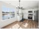 Modern kitchen with stainless appliances, island sink, and a view of the backyard pond at 3155 N White River Pkwy E Dr, Indianapolis, IN 46208