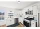Modern kitchen features white cabinets, stainless steel appliances, and wood-look floors at 3155 N White River Pkwy E Dr, Indianapolis, IN 46208