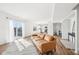 Open-concept living room with hardwood floors, an outdoor deck, and connecting kitchen at 3155 N White River Pkwy E Dr, Indianapolis, IN 46208