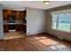 Sunlit living room featuring hardwood floors, neutral walls, and a glimpse into the kitchen at 316 Elm St, Greenwood, IN 46142