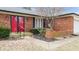 Close up of brick home, red front door, mature landscaping, and attached garage at 3779 W County Line Rd, Greenwood, IN 46142
