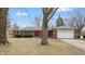 Inviting brick home with a charming red door and well-manicured front yard at 3779 W County Line Rd, Greenwood, IN 46142