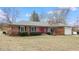 Charming brick ranch-style home with a red front door, attached garage, and manicured landscaping at 3779 W County Line Rd, Greenwood, IN 46142
