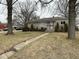 Charming stone home with mature trees and walkway to the front entrance at 3851 N Campbell Ave, Indianapolis, IN 46226