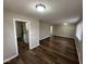 Open-concept living room with view into kitchen, featuring new dark wood floors at 3851 N Campbell Ave, Indianapolis, IN 46226