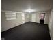 The living room has fresh paint and new carpet, with a view into the kitchen and a large window at 3851 N Campbell Ave, Indianapolis, IN 46226