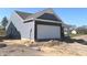 A side view of a new construction with an attached garage and light blue siding in a rural environment at 3885 Berkdale Ct, Columbus, IN 47203