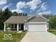 Charming single-story home featuring a two-car garage, well-manicured lawn and classic architectural details at 3885 Berkdale Ct, Columbus, IN 47203