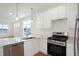 Modern kitchen with stainless steel appliances, white cabinets, and stylish lighting at 3913 Wren Dr, Brownsburg, IN 46112