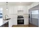 Modern kitchen with stainless steel appliances, sleek white cabinetry, and quartz countertops at 3913 Wren Dr, Brownsburg, IN 46112