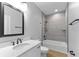 Modern bathroom with gray tile, a white sink, a black faucet, and modern vanity lighting at 4054 Boulevard Pl, Indianapolis, IN 46208