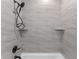 Bathroom shower and tub features gray tile, a shower head, a faucet, and built-in shelving at 4054 Boulevard Pl, Indianapolis, IN 46208