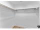 Walk-in closet with hardwood floors, white walls, and a wooden closet rod with white shelving at 4054 Boulevard Pl, Indianapolis, IN 46208